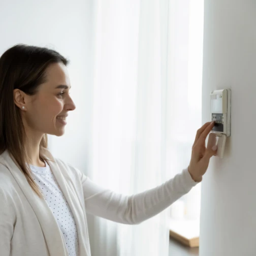 woman adjusting thermostat